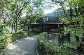 A picturesque view of Hakushu Distillery surrounded by lush green forests in the Japanese Alps.